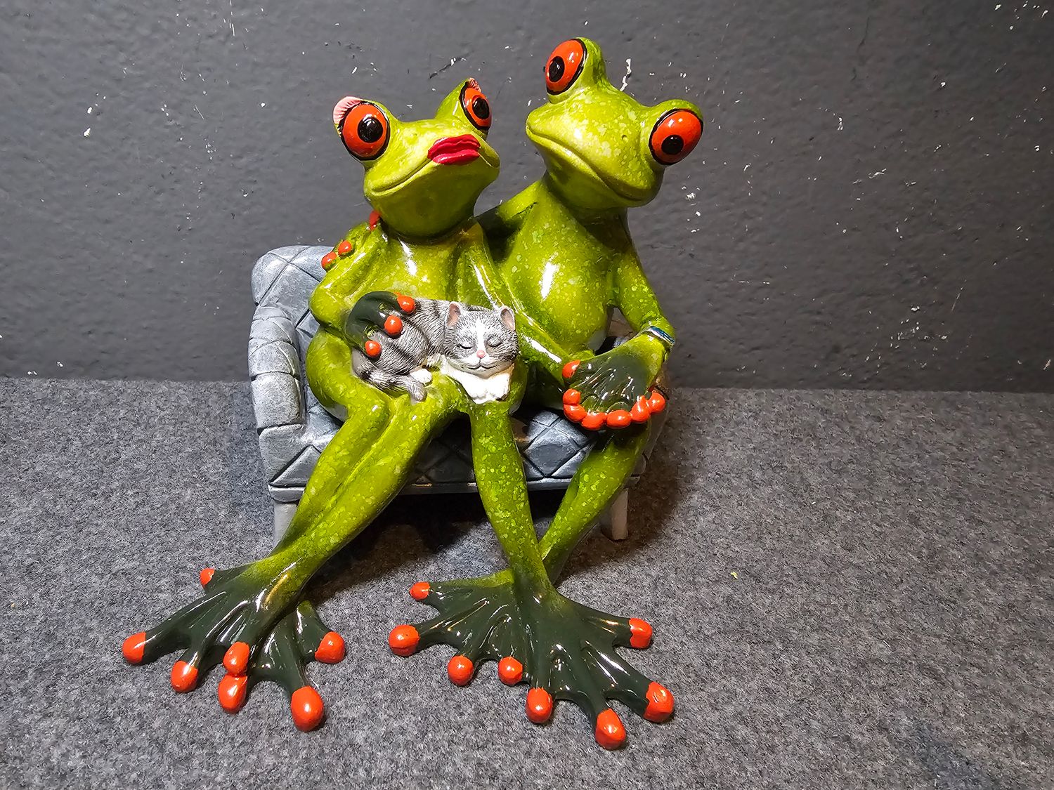 Żaba para na sofie z szarym kotkiem na kolanach