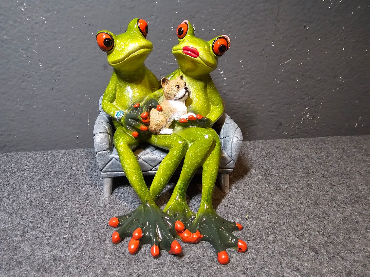 Żaba para na sofie z pieskiem na kolanach