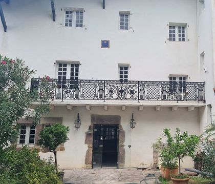 Balcon ancien en fonte allongé d'éléments en fer forgé de grosse section Balcon ancien en fonte allongé d'éléments en fer forgé de grosse section