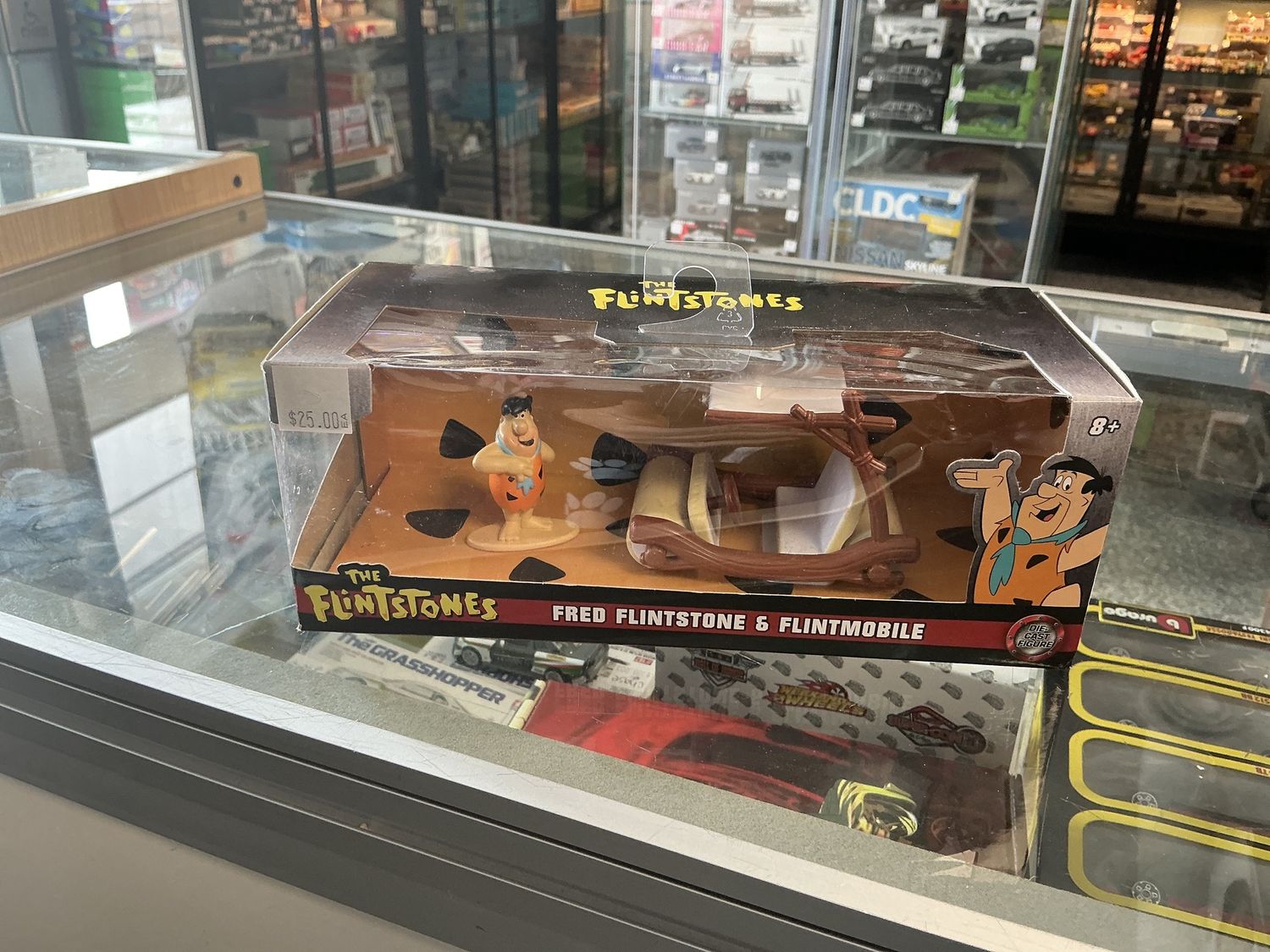 Fred Flintstone with the Flint mobile