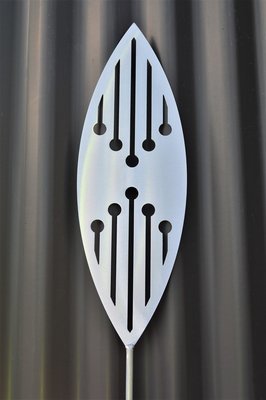 Reflection Aluminium Spear by Grounded Art NZ &amp; a dark clad building. The bright metal art pops against the dark background.