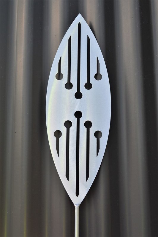 Reflection Aluminium Spear by Grounded Art NZ &amp; a dark clad building. The bright metal art pops against the dark background.