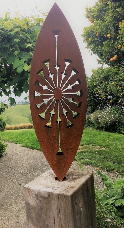 Rusty 3D Corten Tohu sculpture by Grounded Art NZ designed to burst into your landscape. In a lush established garden.