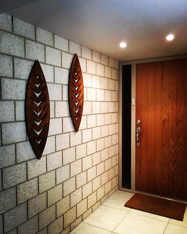 2 Corten Steel Wall Art Shields by Grounded Art NZ on an entry way wall. The contrast of rusty patina against natural stone.