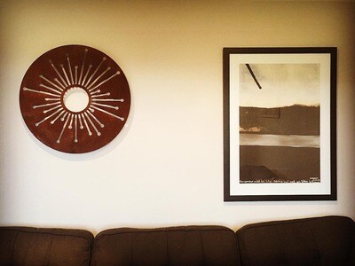 Corten Allium Wall Art by Grounded Art NZ in a New Zealand living room alongside Colin McCahon artwork. Rusty Patina indoors.