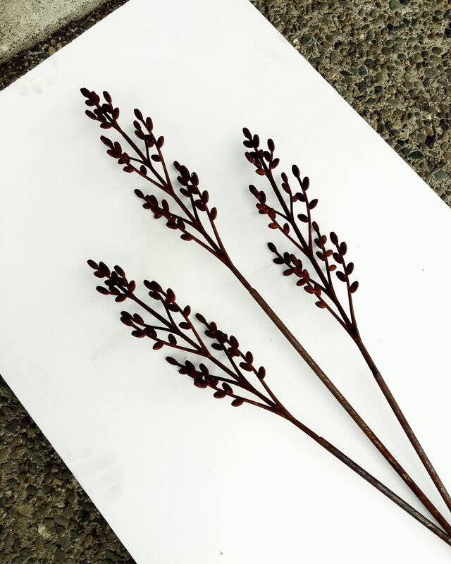 3 Toi Wands by Grounded Art NZ. The bold rusty patina and intricate design of each wand stands out against light backgrounds.