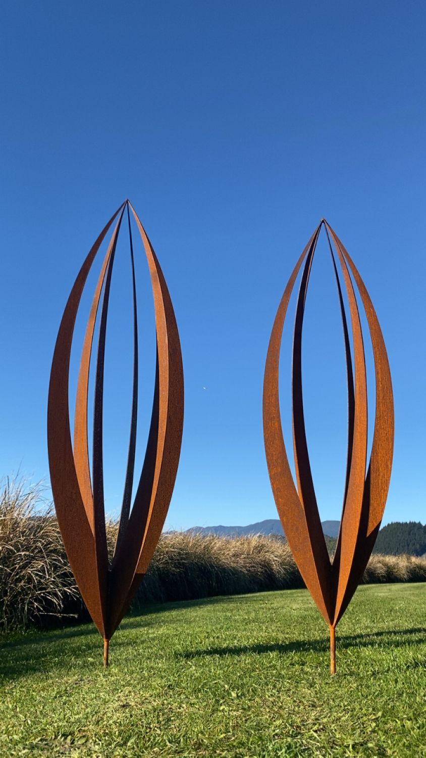 Close up of the metal curves from Rusty Corten Pods by Grounded Art NZ with a clear blue sky. NZ made Metal Art.