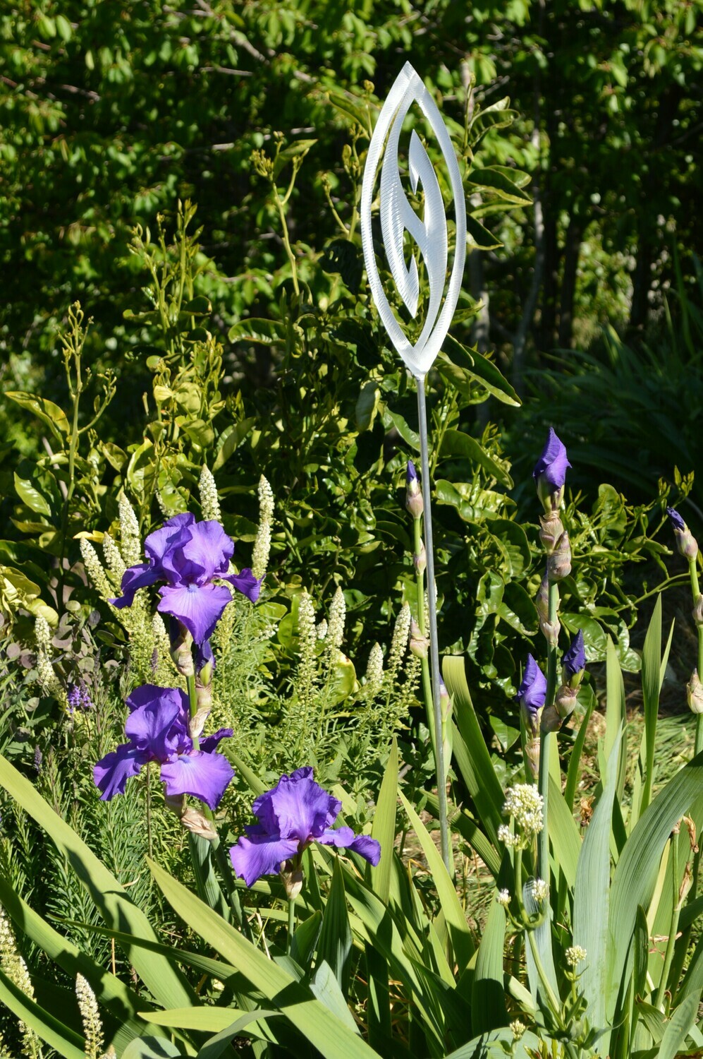 Fish Hook Aluminium Garden Art Spear by Grounded Art NZ in an established lush green NZ garden with Mignonette and irises.