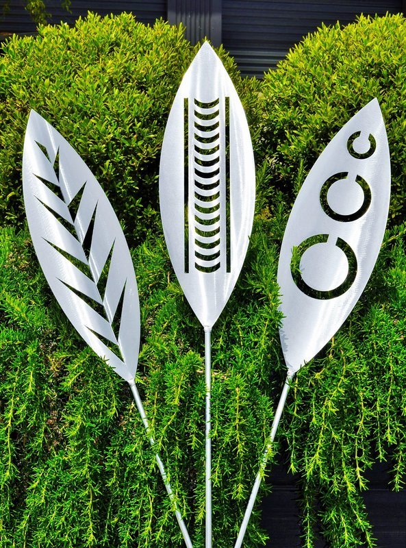 Leaf, Nikau and Tribal designs of Aluminium spears made by Grounded Art NZ in a Rosemary shrub, South Otago, New Zealand. 