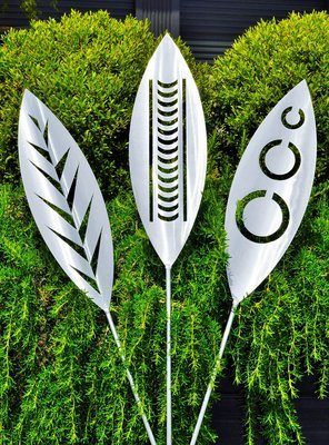 Leaf, Nikau and Tribal designs of Aluminium spears made by Grounded Art NZ in a Rosemary shrub, South Otago, New Zealand. 