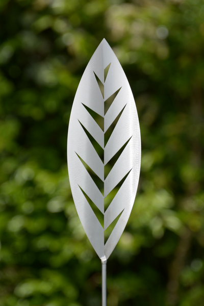 Aluminium Leaf spear by Grounded Art NZ. Glistening bright Aluminium metal art with a lush green native NZ garden behind.