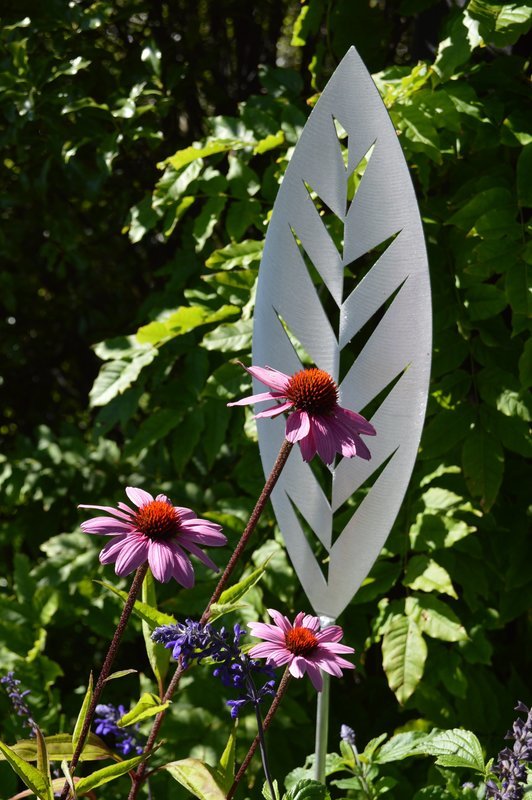 Aluminium Leaf spear by Grounded Art NZ. Glistening bright Aluminium metal art in a lush green established garden.