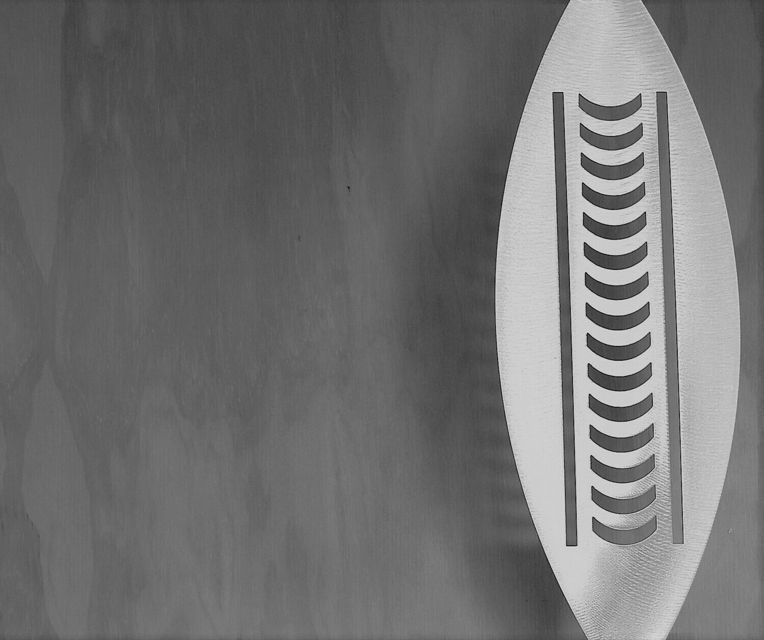 Nikau Aluminium Spear by Grounded Art NZ in a gallery setting where the shadows are cast onto the pale plywood wall behind.