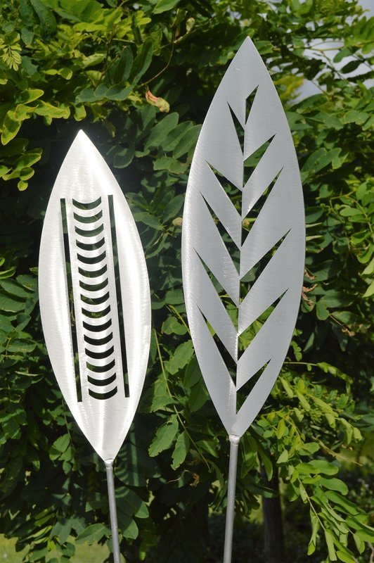 Nikau and Leaf designs of Aluminium Garden Art Spears by Grounded Art NZ in an established lush green native NZ garden. 