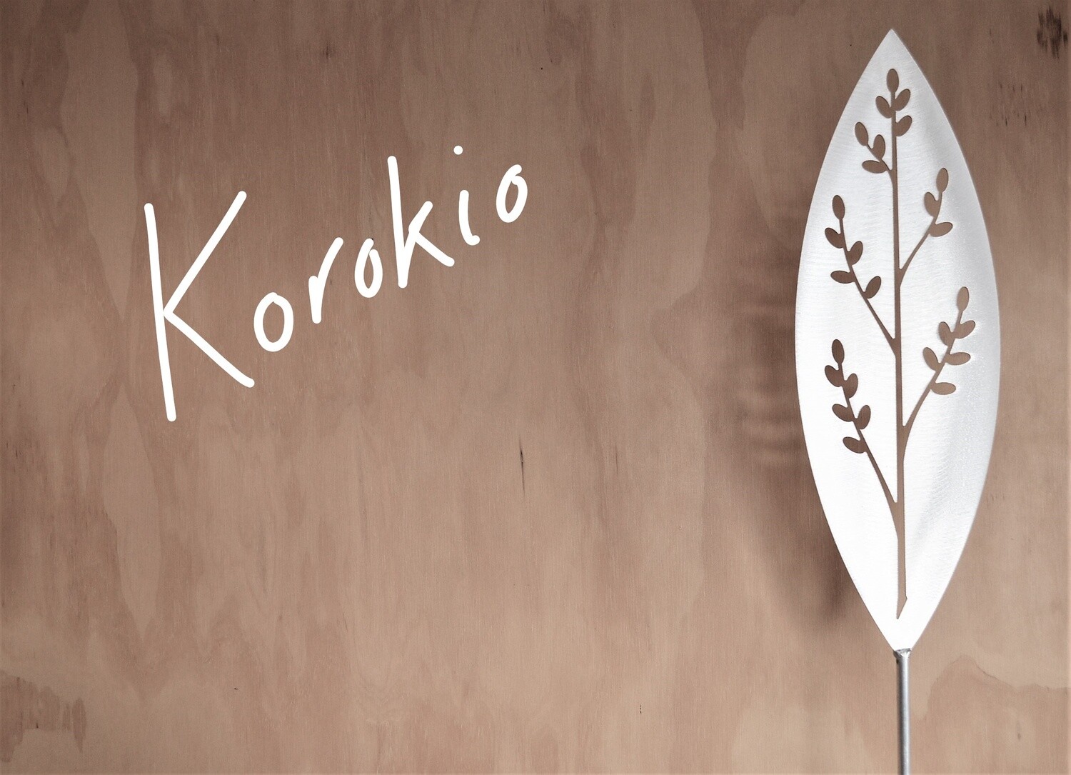 Korokio Aluminium Spear by Grounded Art NZ in a gallery setting where the shadows are cast onto the pale plywood wall behind.