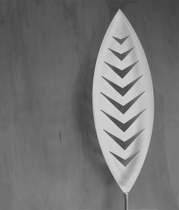 Arrow Aluminium Spear by Grounded Art NZ in a gallery setting where the shadows are cast onto the pale plywood wall behind.
