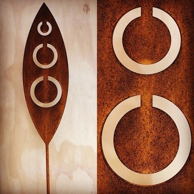Corten garden spear by Grounded Art NZ in Tribal design. Rusty patina of the Corten highlighted by the pale plywood wall.