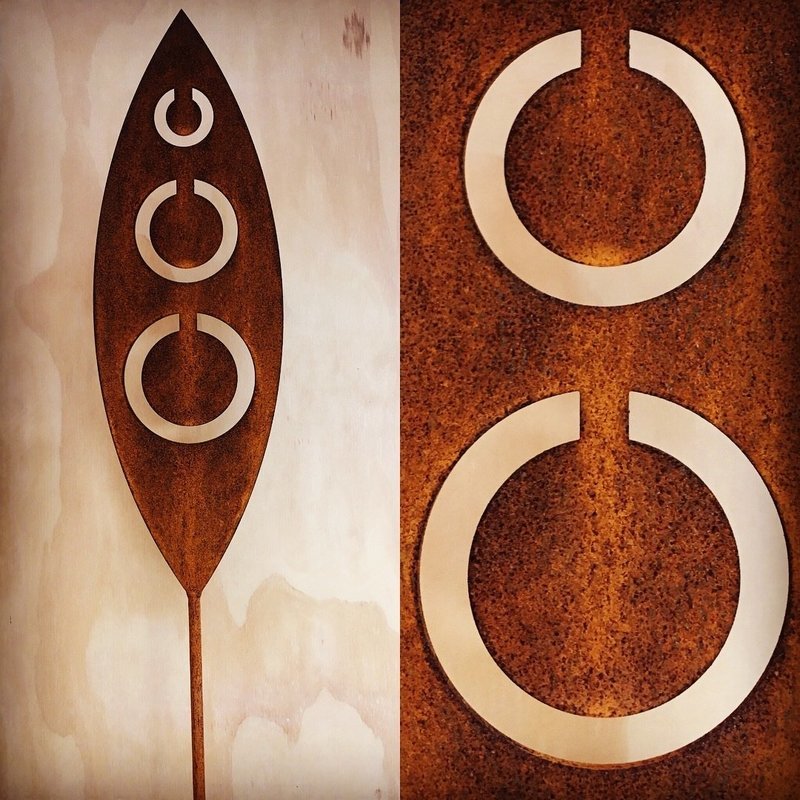 Corten garden spear by Grounded Art NZ in Tribal design. Rusty patina of the Corten highlighted by the pale plywood wall.