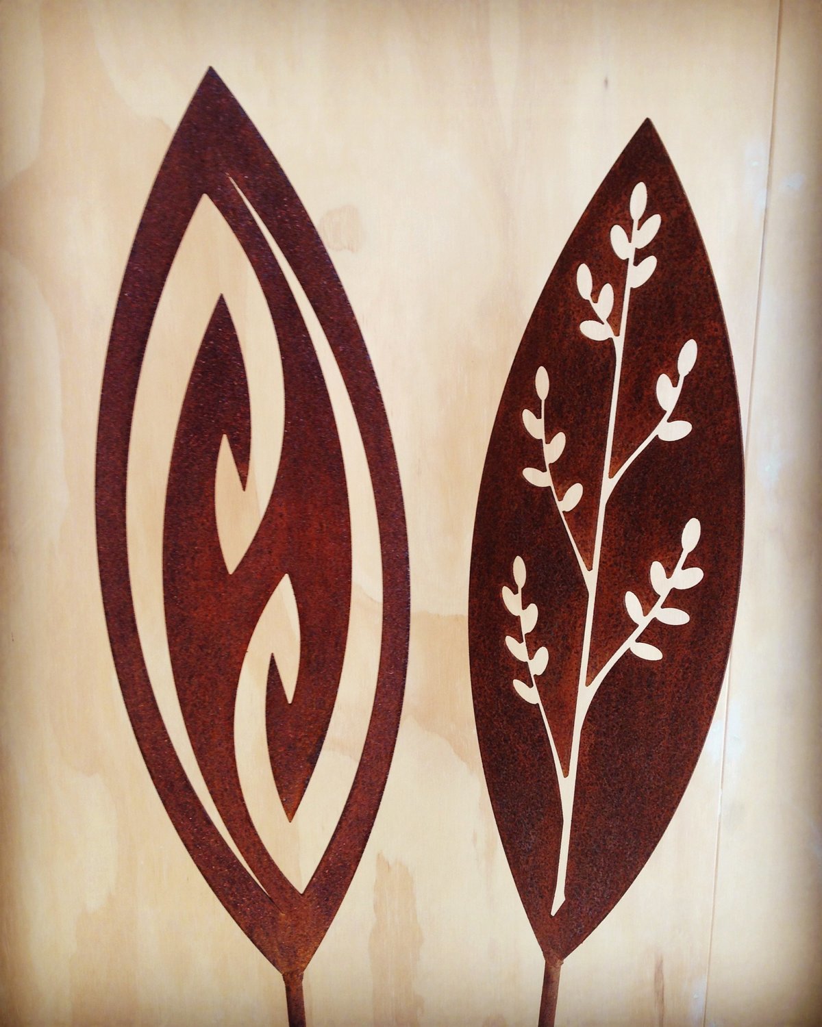 Corten Spears in Fish Hook and Korokio designs by Grounded Art NZ. Rusty Corten patina with a pale gallery background.
