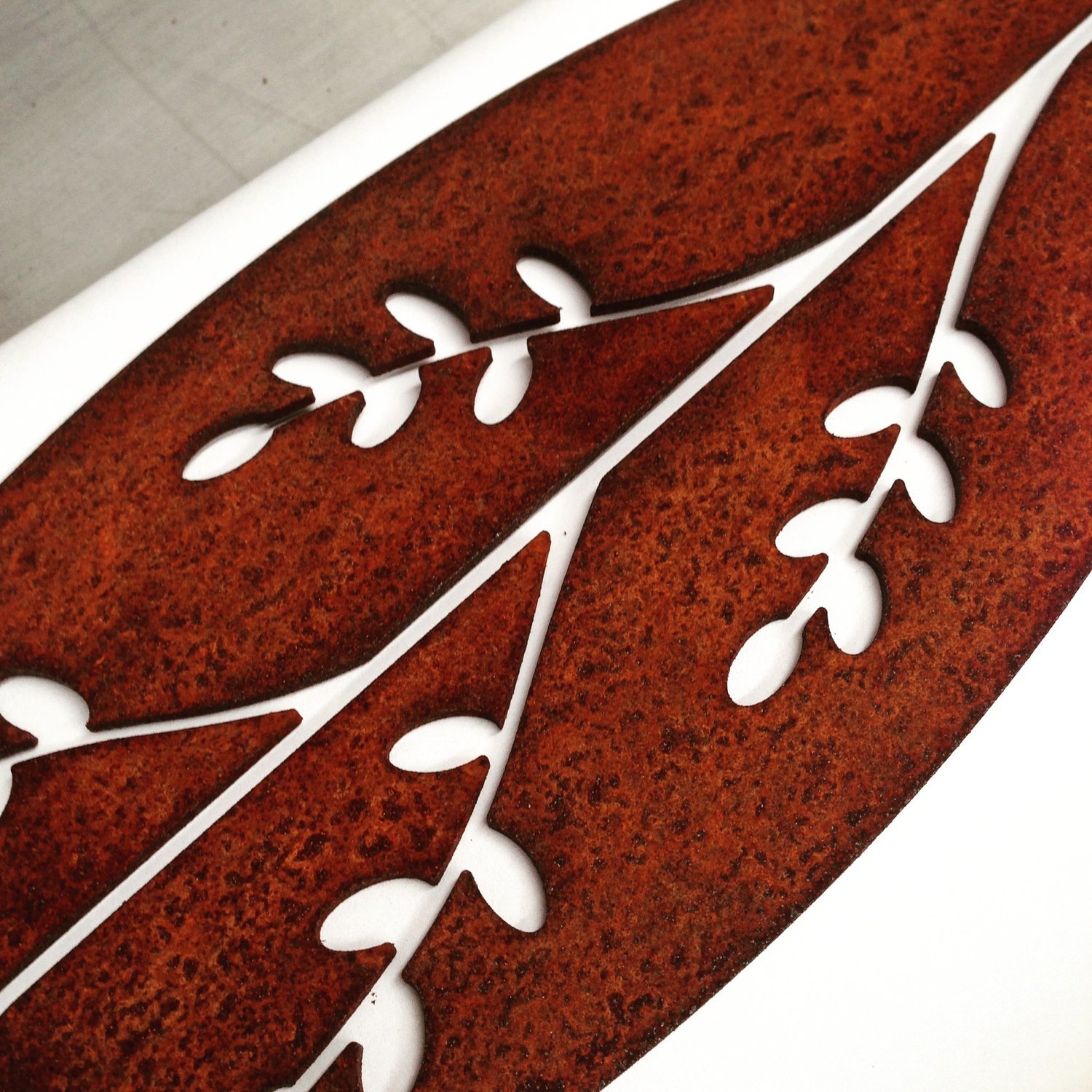 Corten Spear in Korokio design by Grounded Art NZ. Korokio detail in rusty Corten patina with a pale white background.