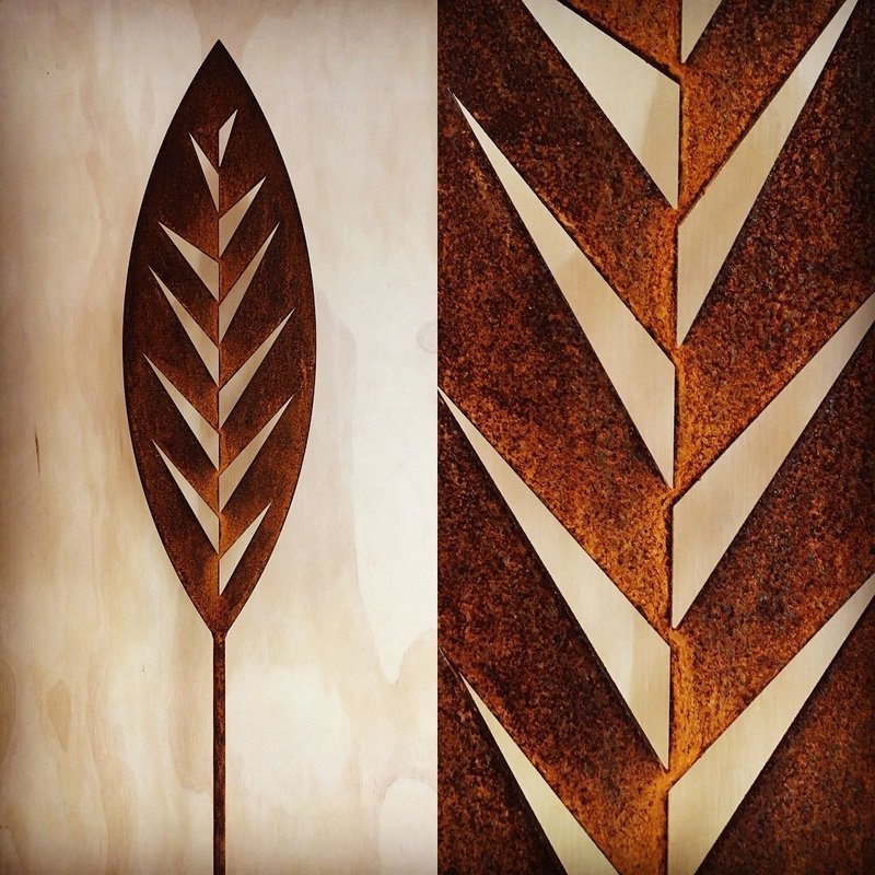 Rusty Leaf Corten Spear by Grounded Art NZ in a gallery setting. Bright glow of the rusty patina against a light background.