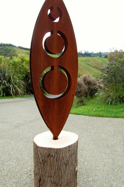 Close up look at the Tribal sculpture design by Grounded Art NZ. Sculpture is displayed in a natural wooden log. 
