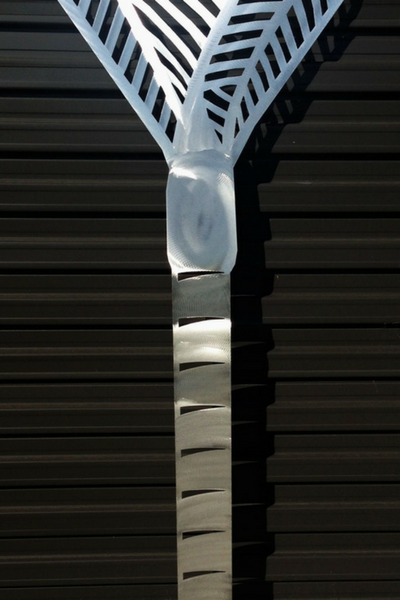 Aluminium Nikau Palm Wall Art by Grounded Art NZ catching the light with its glistening sanded detail on the trunk.