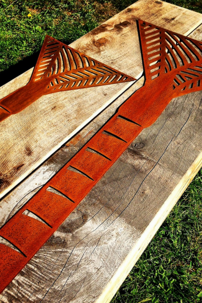 2 Corten Nikau Palm Wall Art by Grounded Art NZ. Bright rusty patina stands out against natural wooden slabs. South Otago, NZ