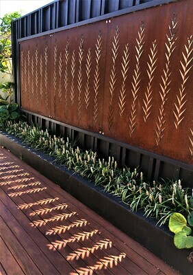 Corten Leaf screens by Grounded Art NZ. Rusty patina privacy screen letting light through onto a timber deck. 