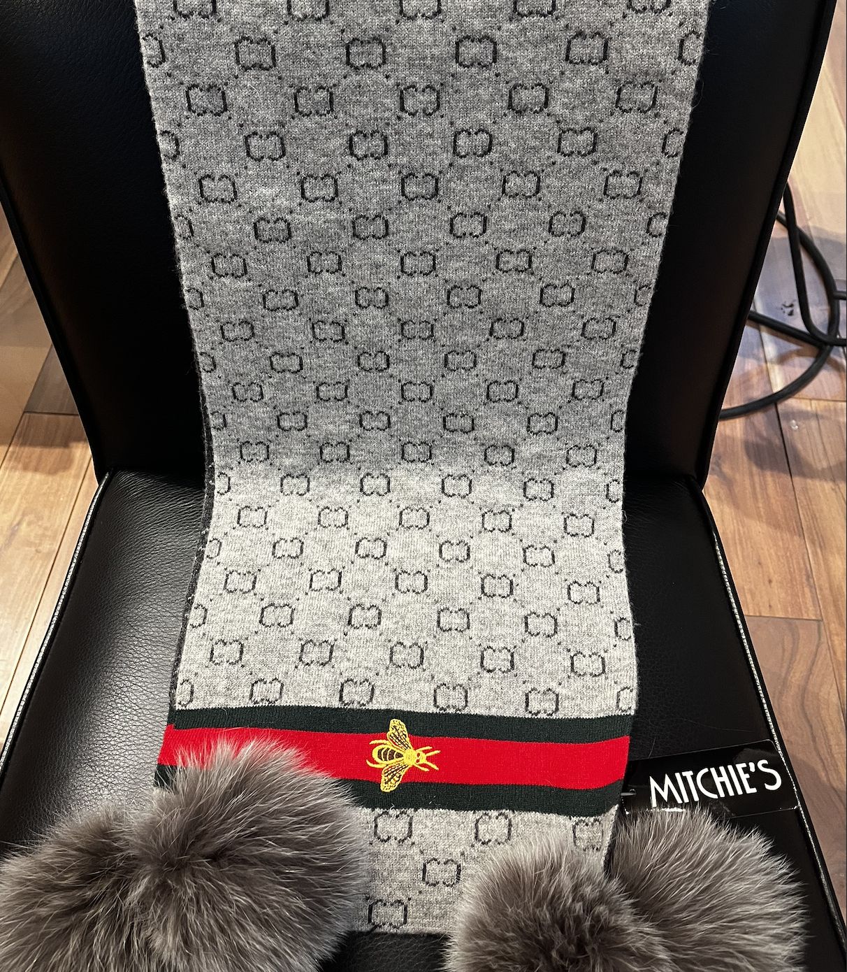 Grey knitted scarf with embodied bee on boarder