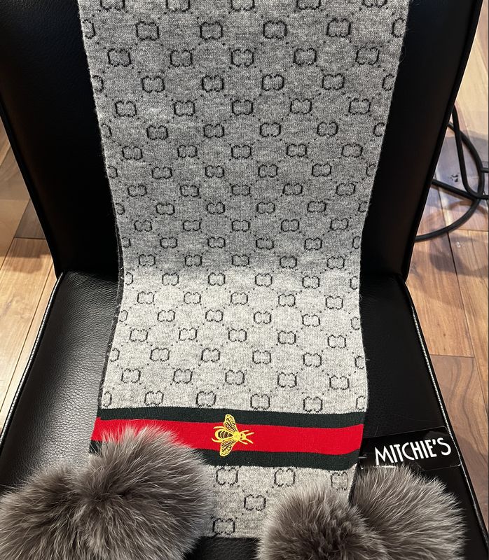 Grey knitted scarf with embodied bee on boarder