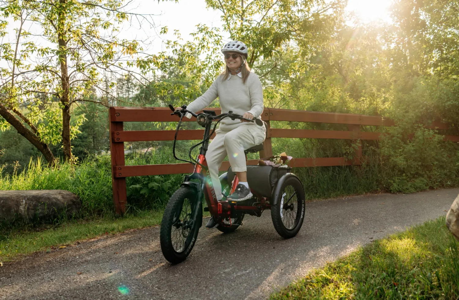 Woman riding her Velotric Triker Etrike in Red