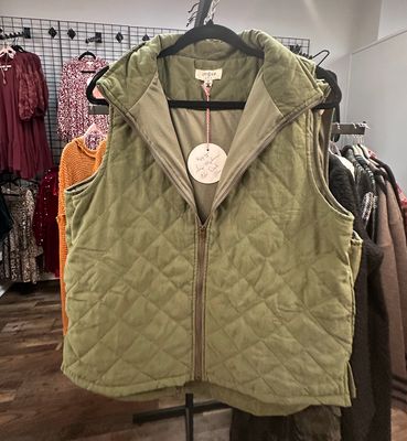 Umgee Ladies Full-Zip Quilted Vest hanging on a rack in Merle Norman, Elizabethton | GiGi's Boutique.