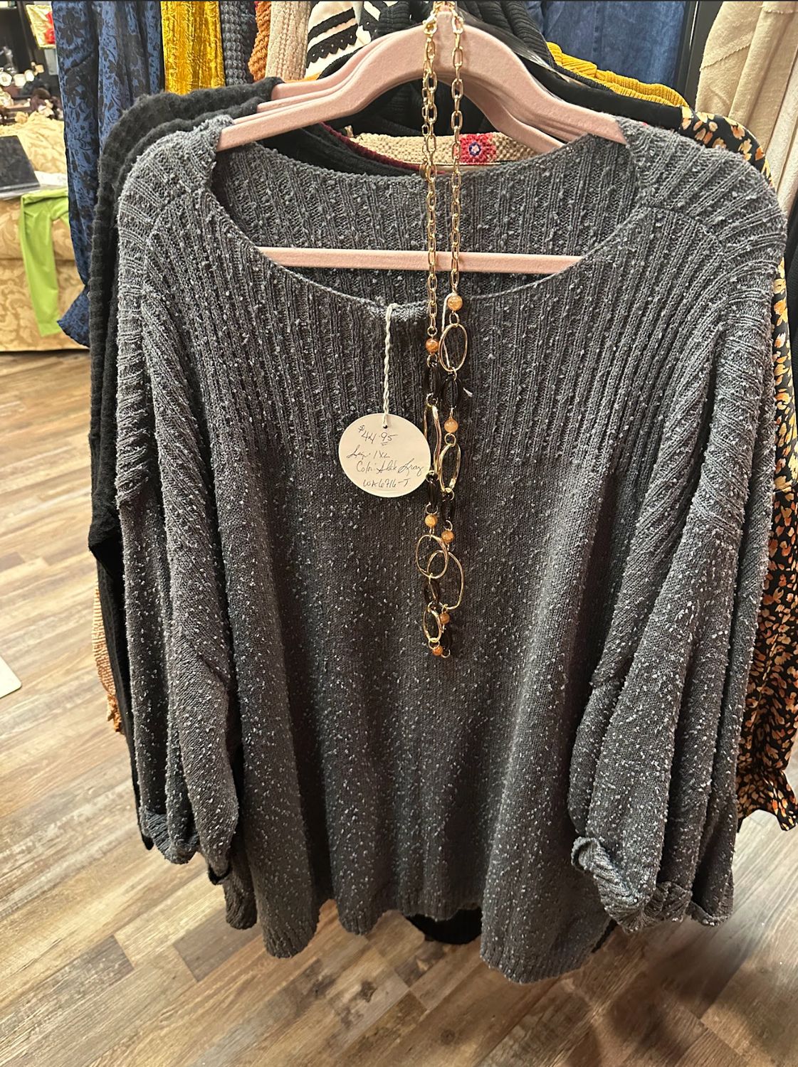 Umgee Flowy Long-Sleeve Wideneck Shirt hanging on a rack at Merle Norman Elizabethton. 
