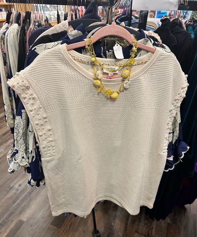 Umgee Ladies Sleeveless Pearl Blouse on a rack at Merle Norman Elizabethton. 