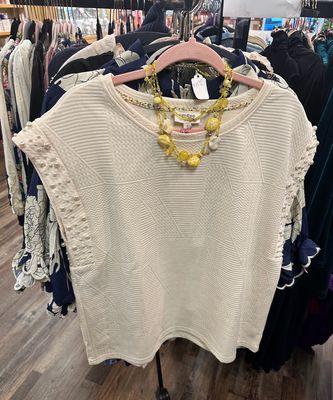 Umgee Ladies Sleeveless Pearl Blouse on a rack at Merle Norman Elizabethton. 