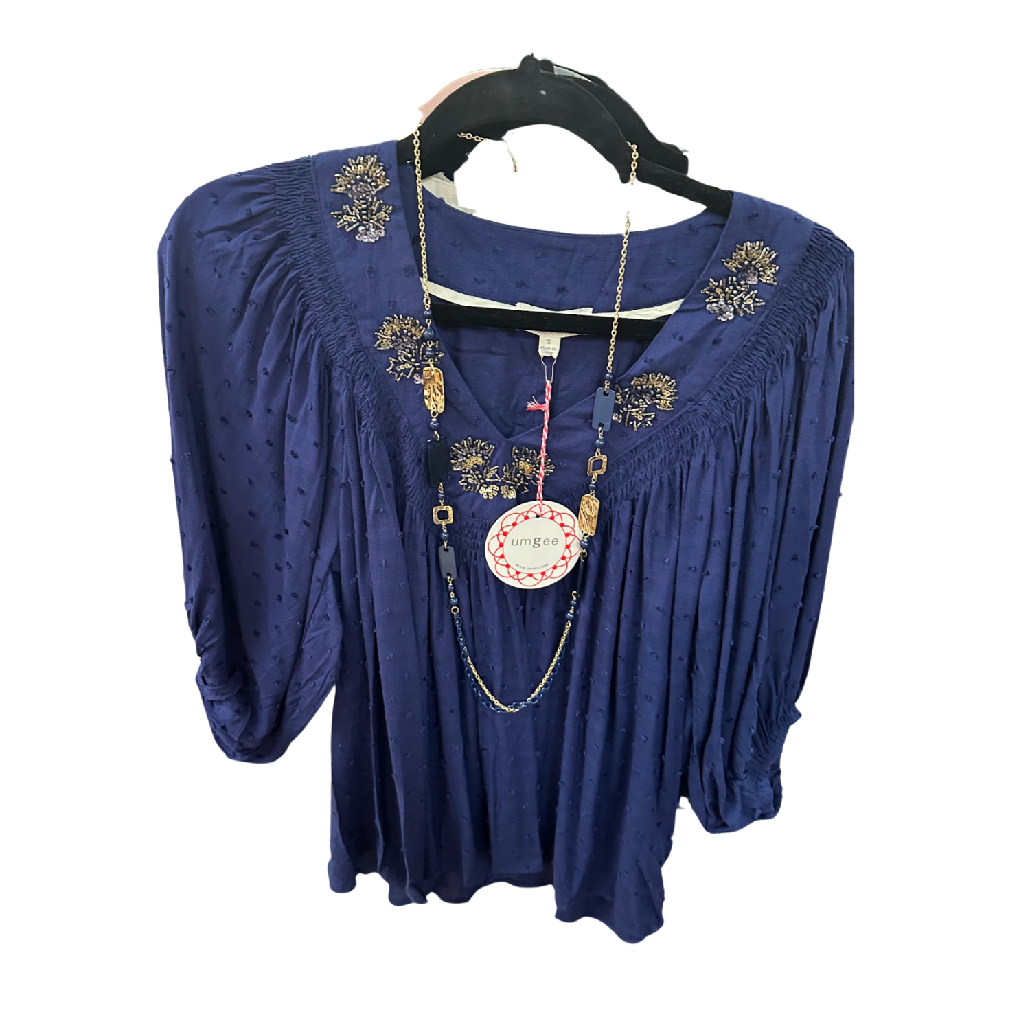 Umgee Deep Blue Flowy Blouse on a rack at Merle Norman Elizabethton. 