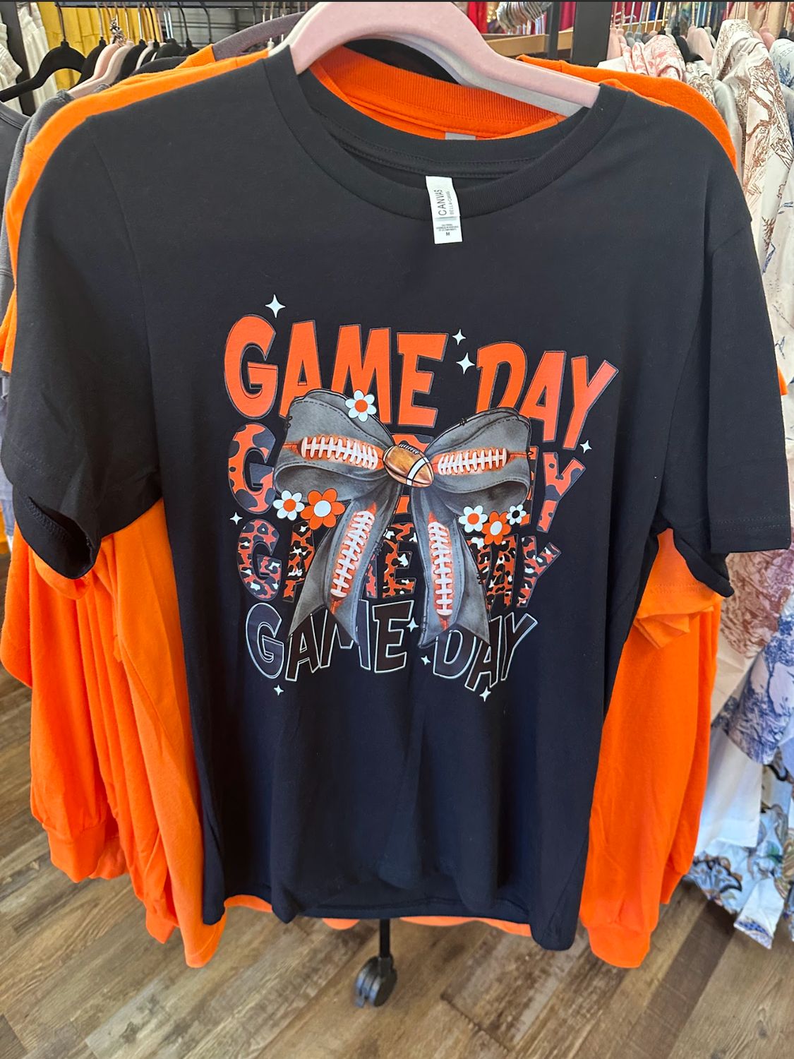 The Black Ladies' UT Vols Game Day T-shirt is hanging on a rack at Merle Norman Elizabethton. 