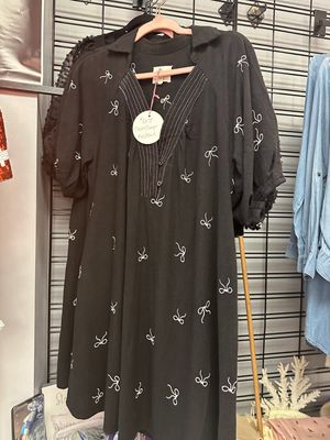 Umgee Black Ribbon Print Flowy Dress on a rack in Merle Norman Elizabethton. 