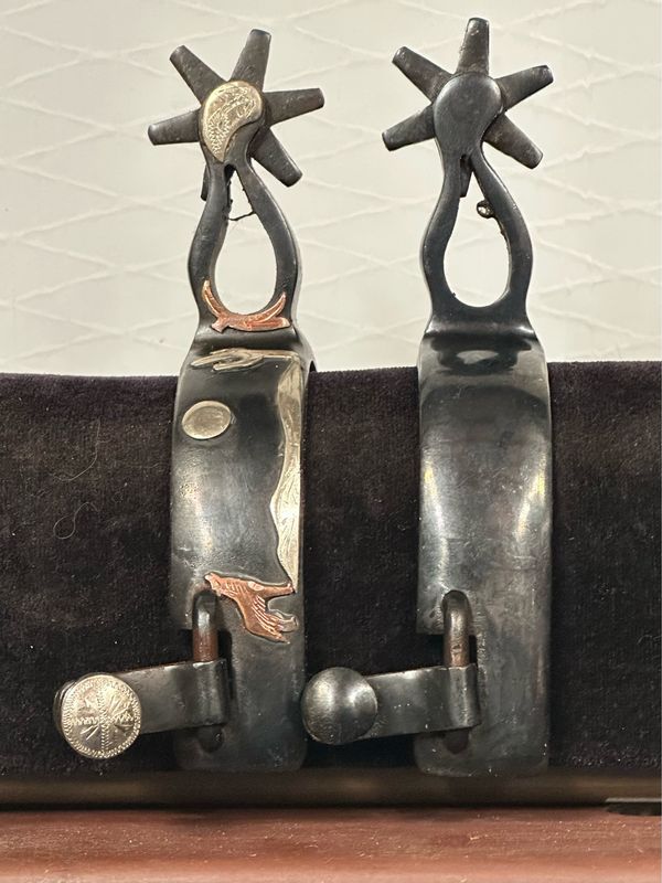 Men’s Western Spurs in Polished Black Steel with Howling Coyote Moon Trim on a 1” Width Band and Teardrop Shape Shanks with 6 Point Rowels