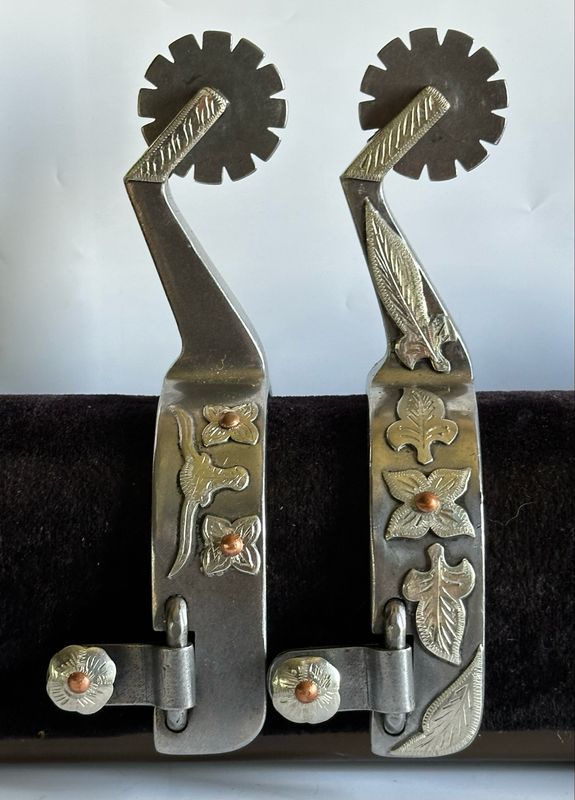 Men’s Western Spurs with a 1- inch Width Polished Steel Band with GS Longhorn and Floral Trim and 3- inch Length Shanks With GS Feather Trim and Bars and 12- Point Rowels 060926