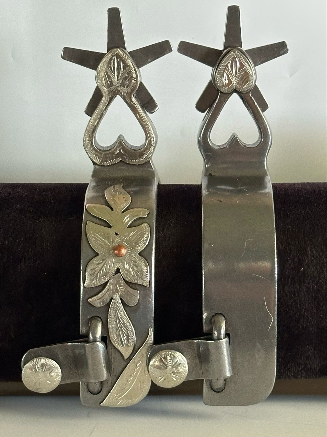 Men’s Western Spurs with a 1 1/4- inch Width Polished Steel Band with GS Floral Trim and 2 3/8- inch Length Heart Shaped Shanks with GS Trim and 5 Point Rowels 060926
