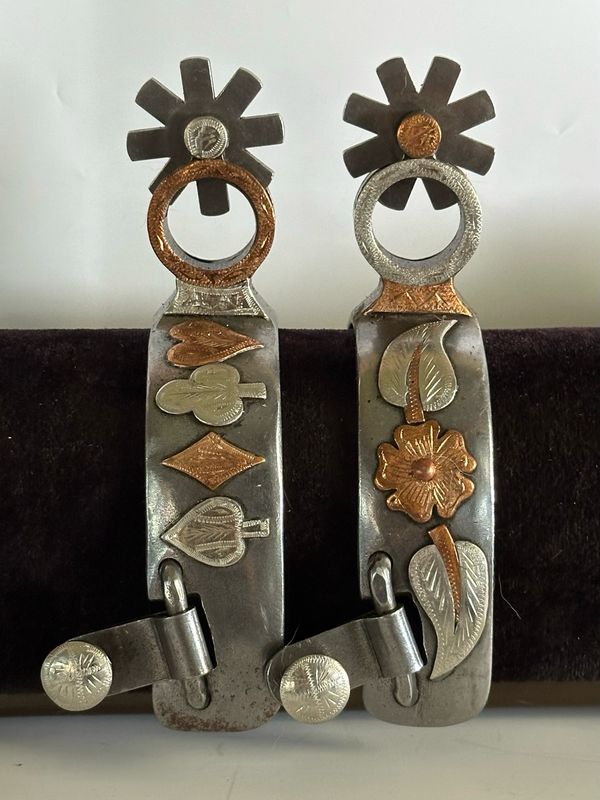 Men’s Western Spurs with a 1 1/4- inch Width polished Steel Band with Card Symbols and Floral Copper and Gs Trim and Circular 1 3/4- inch Length Shanks with Copper and GS Trim and 8 Point Rowels 06096
