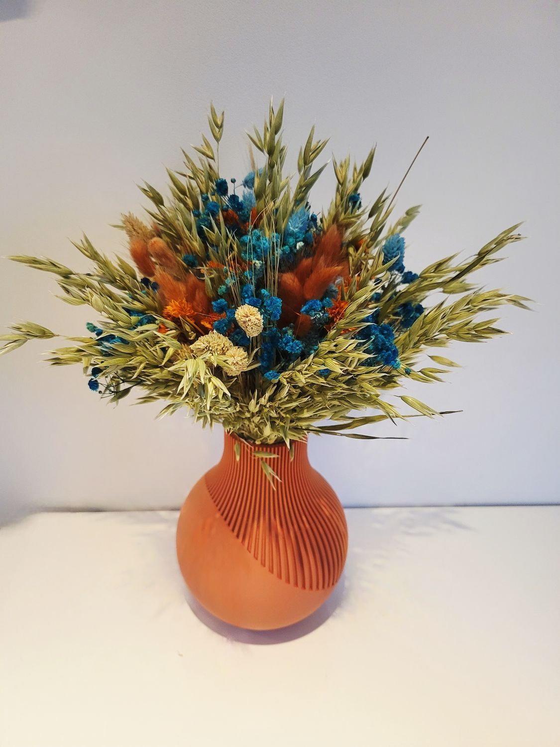 Moderne terracotta gekleurde 3Dprint-vaas met boeket droogbloemen