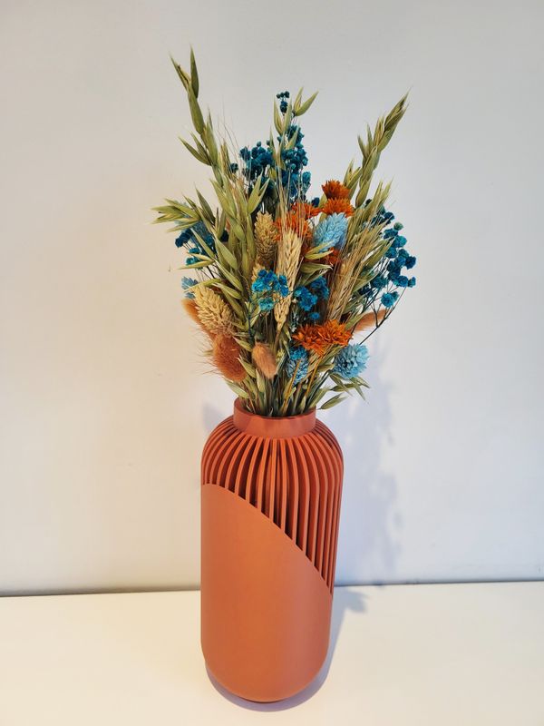 Moderne terracotta gekleurde vaas met droogbloemen