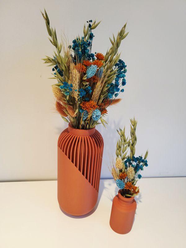 Klein terracotta vaasje gevuld met droogbloemen