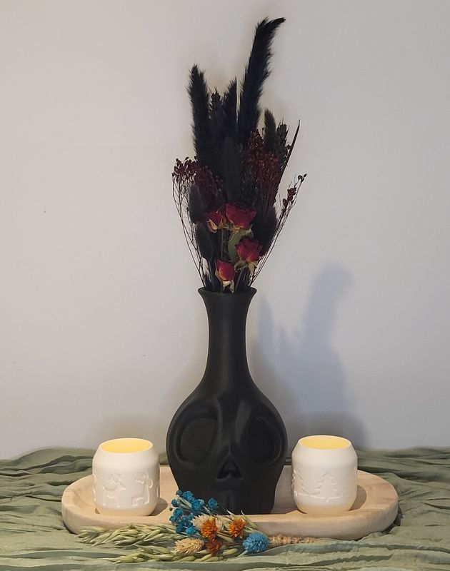 Skull vaas gevuld met droogbloemen en theelichthouders op schaal