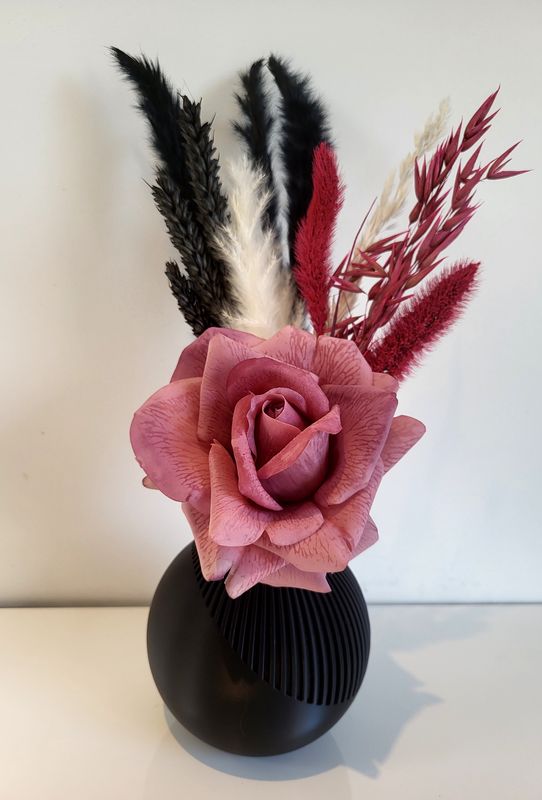 Gekleurd vaasje gevuld met zijdebloem en droogbloemen