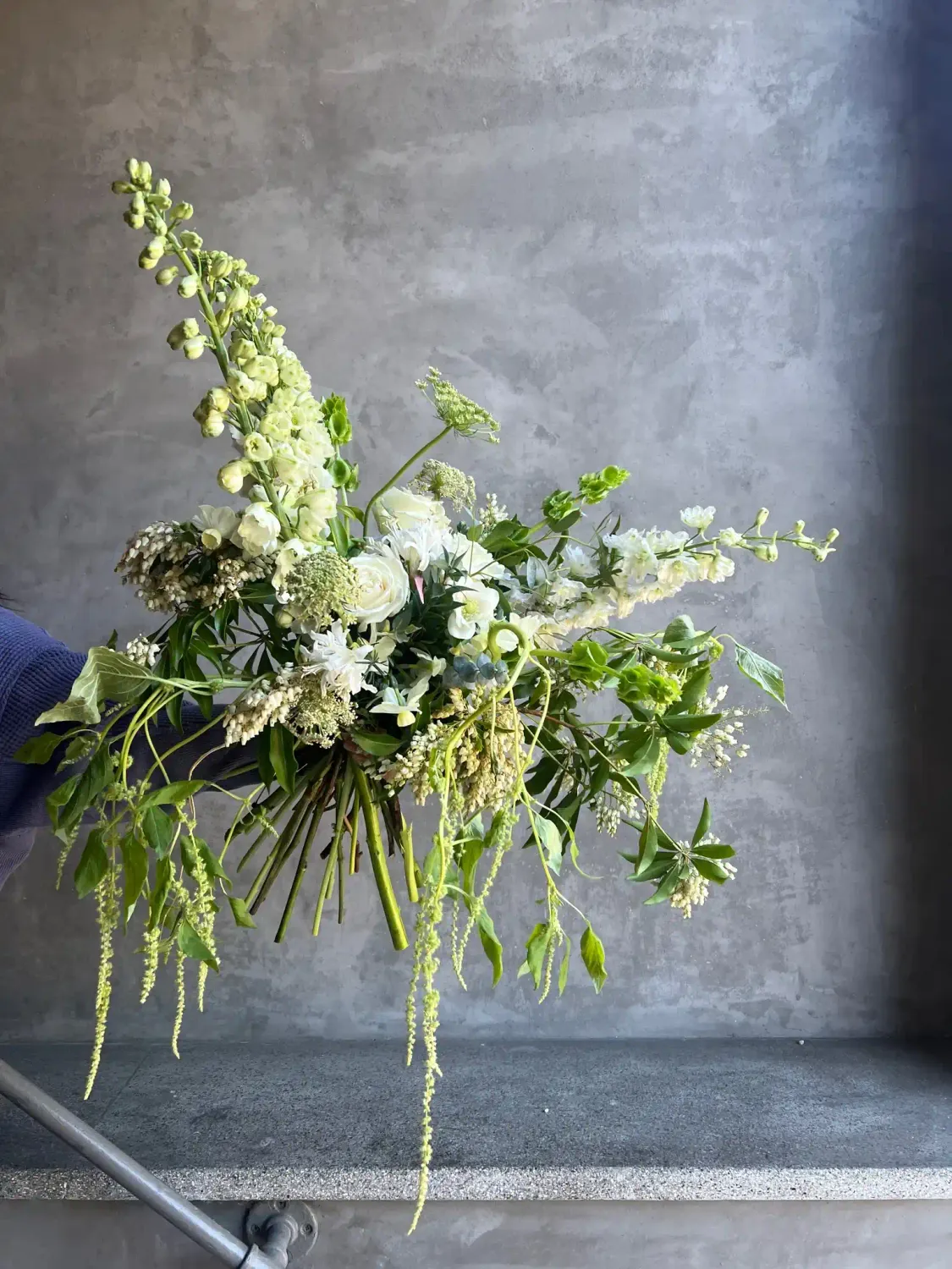 Greens and Things hand held bouquet with white roses bells of ireland and lush greenery San Francisco