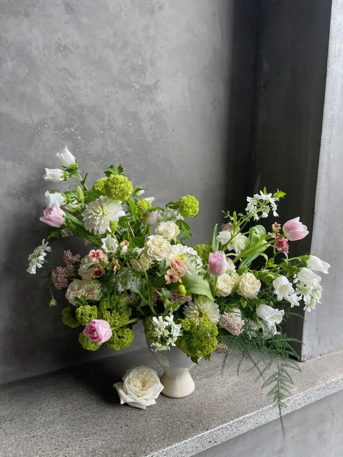 Sweetness arrangement featuring pink tulips, white dahlias, blush roses, and green viburnum in a lush garden style